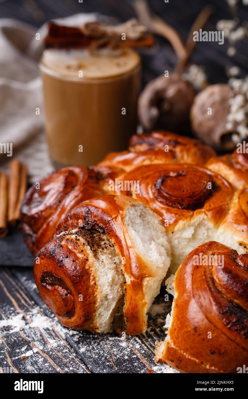 Primo piano di focacce di cannella fatte in casa appena sfornate su un tavolo di legno. Concetto di cottura di Natale. Foto Stock