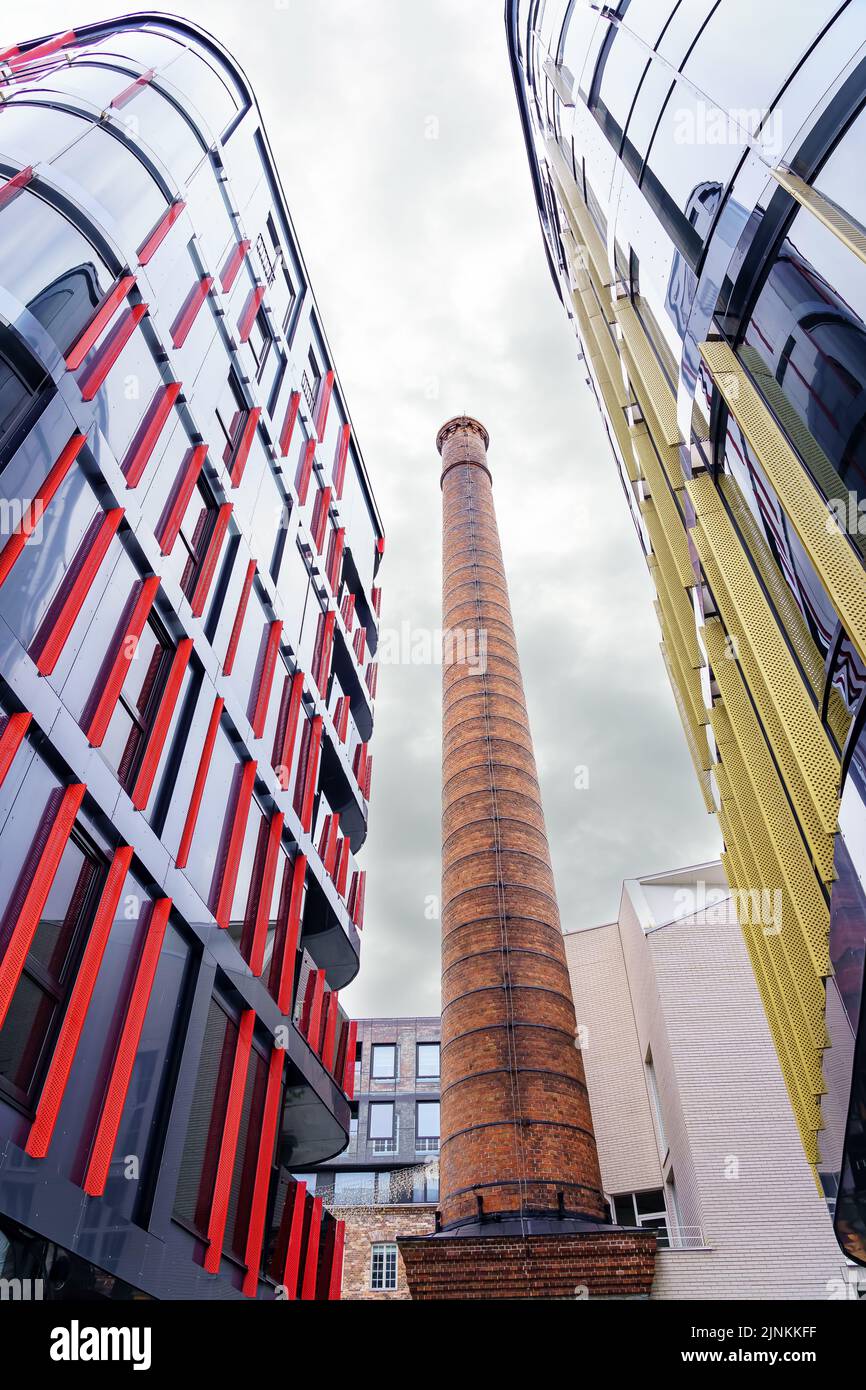 Moderni edifici di vetro vicino alla vecchia torre di mattoni di fabbrica. Tallinn Estonia. Foto Stock