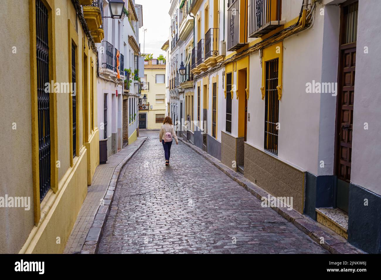 Donna che cammina per le stradine della città medievale di Cordoba in Spagna. Foto Stock