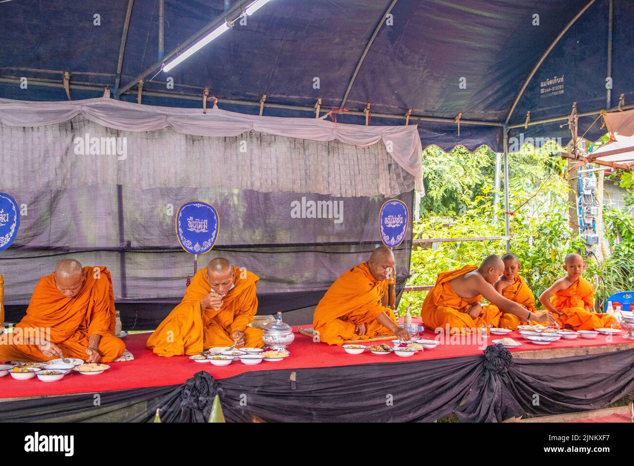 Offerta di cibo o donazione di cibo ai monaci thailandesi come parte di un rituale religioso e buddista in Thailandia sud-est asiatico Foto Stock