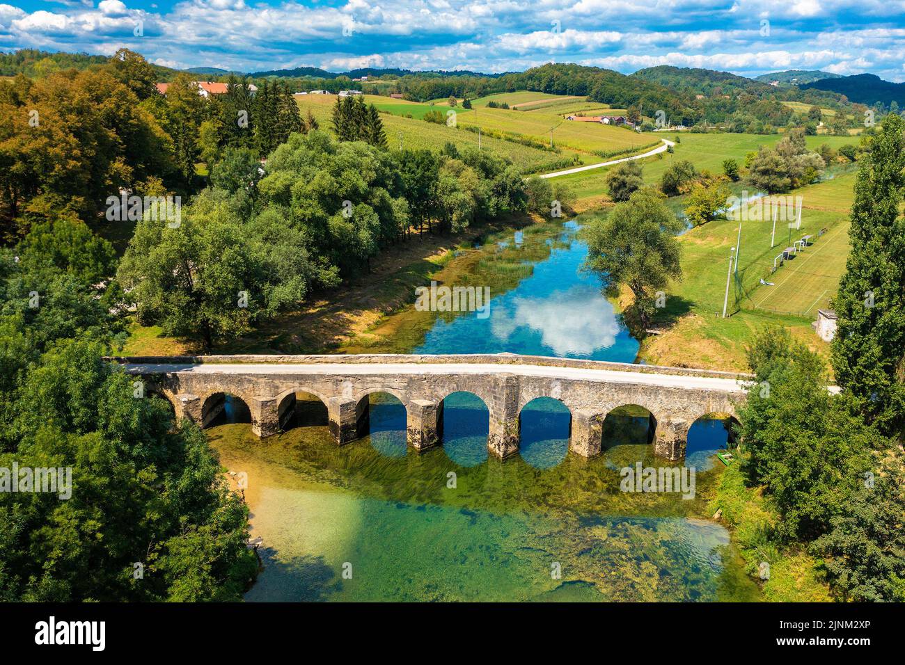 Veduta aerea del vecchio ponte di pietra sul fiume Dobra, Croazia Foto Stock