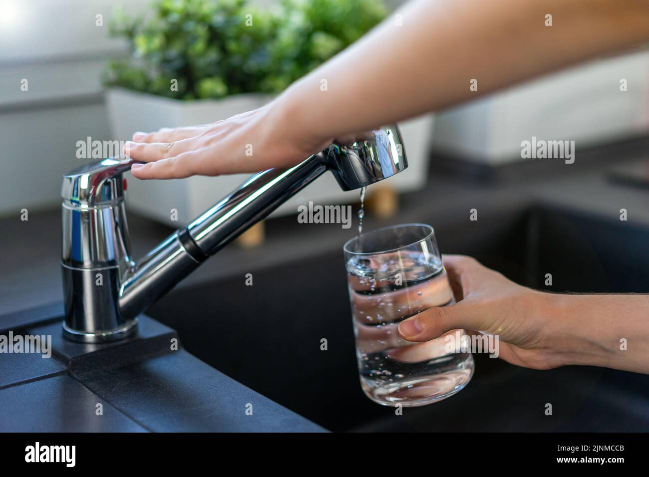 La mano della donna spegne il rubinetto in cucina. Foto Stock