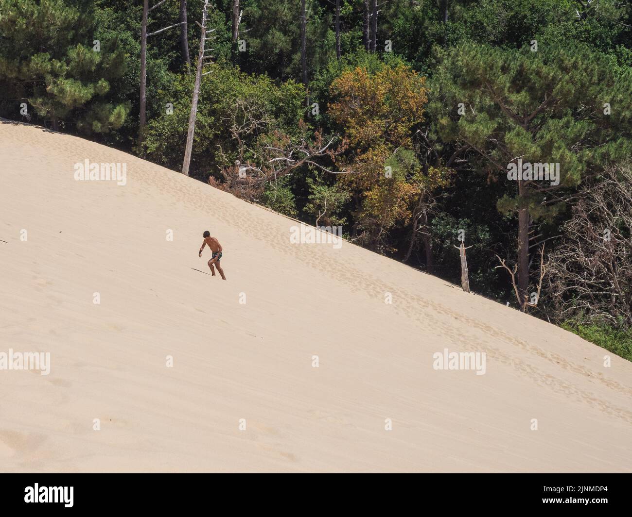 Giovane uomo caucasico che cammina sulla sabbia nella duna du pilat Foto Stock
