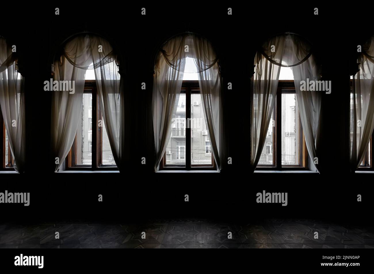 Camera buia con tenda davanti alle vecchie finestre Foto Stock