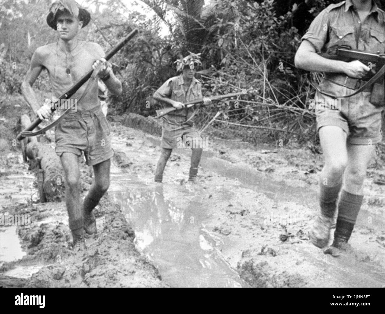 Le truppe australiane avanzano attraverso il fango di pensiero durante la battaglia di Milne Bay sulla punta orientale di New Guineau durante il WW2 Foto Stock