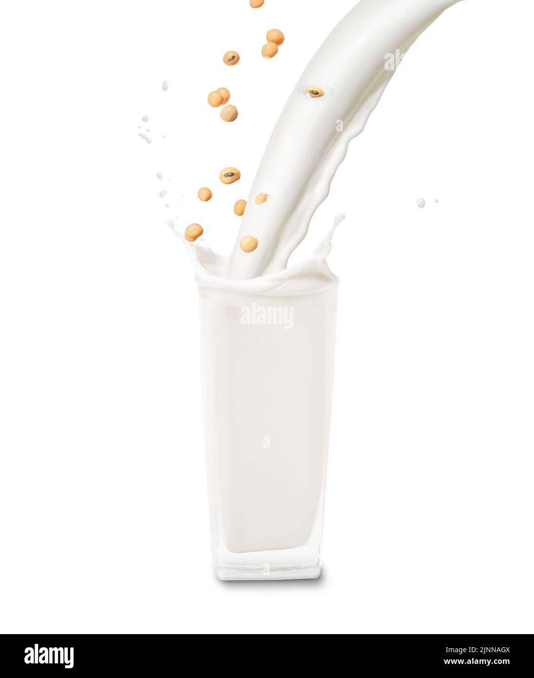 I semi di soia e il getto di latte riempiono il bicchiere grande con lo spruzzo isolato su fondo bianco Foto Stock