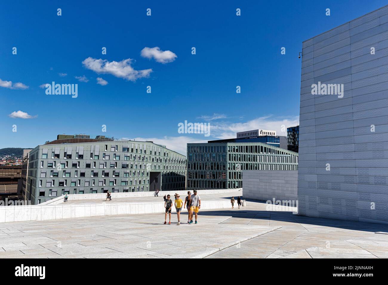 Pedoni sul tetto bianco del teatro dell'opera, architettura moderna, vista dei grattacieli Barcode Project, quartiere di Bjorvika, Bjorvika, Oslo, Norvegia Foto Stock