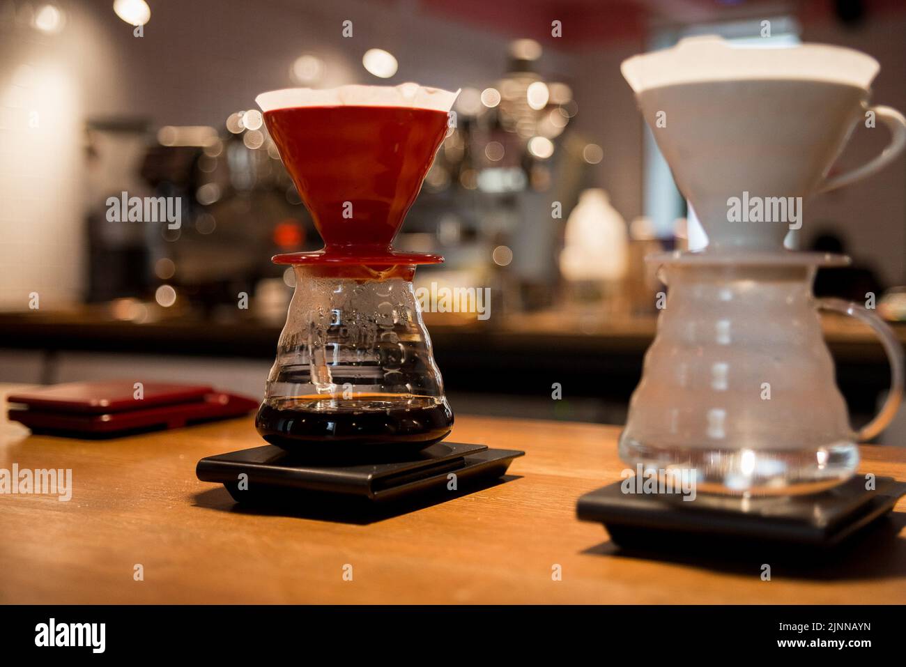 metodo alternativo per preparare il caffè, due imbuti per il caffè si trovano sulla bilancia e preparano bevande calde, filtro per il caffè Foto Stock
