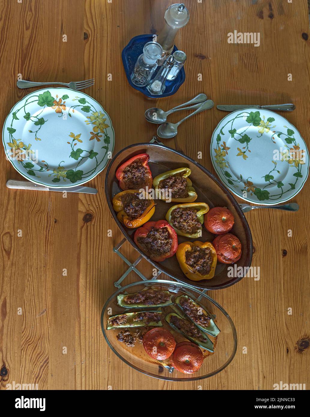 Peperoni ripieni e pomodori in due casseruole sul tavolo da pranzo, Baviera, Germania Foto Stock