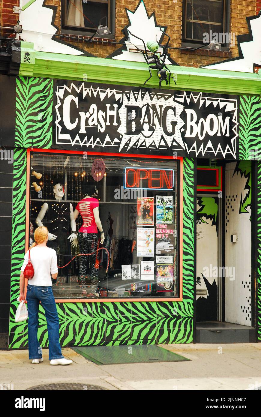 Una giovane donna fuma una sigaretta fuori Crash Boom Bang, un punk e negozio alternativo appena fuori South Street a South Philadelphia Foto Stock