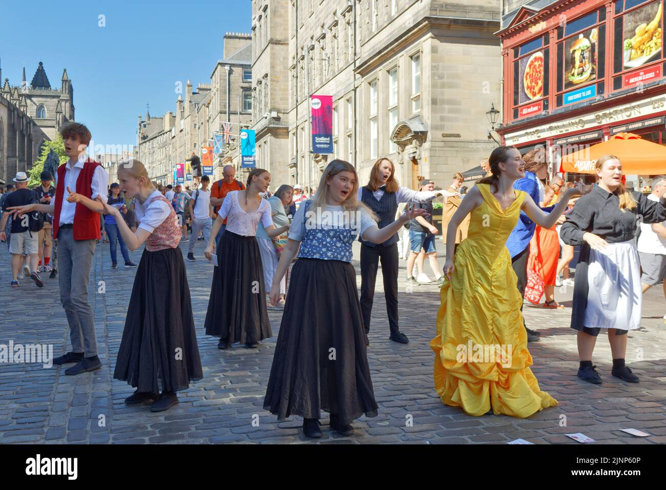 Edimburgo, Scozia, 11 agosto 2022 Festival Fringe in the Royal Mile un gruppo di cantanti e ballerini si esibiscono dal gioco Beauty and the Beast Foto Stock