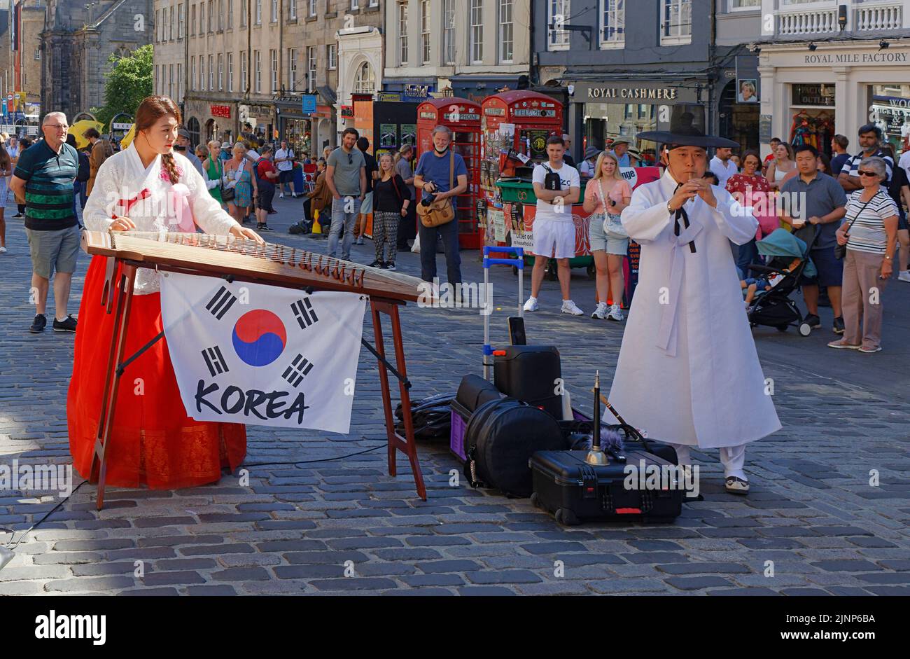 Edimburgo, Scozia, 11 agosto 2022 Festival Fringe in the Royal Mile due musicisti coreani in abito tradizionale suonano i loro strumenti Foto Stock