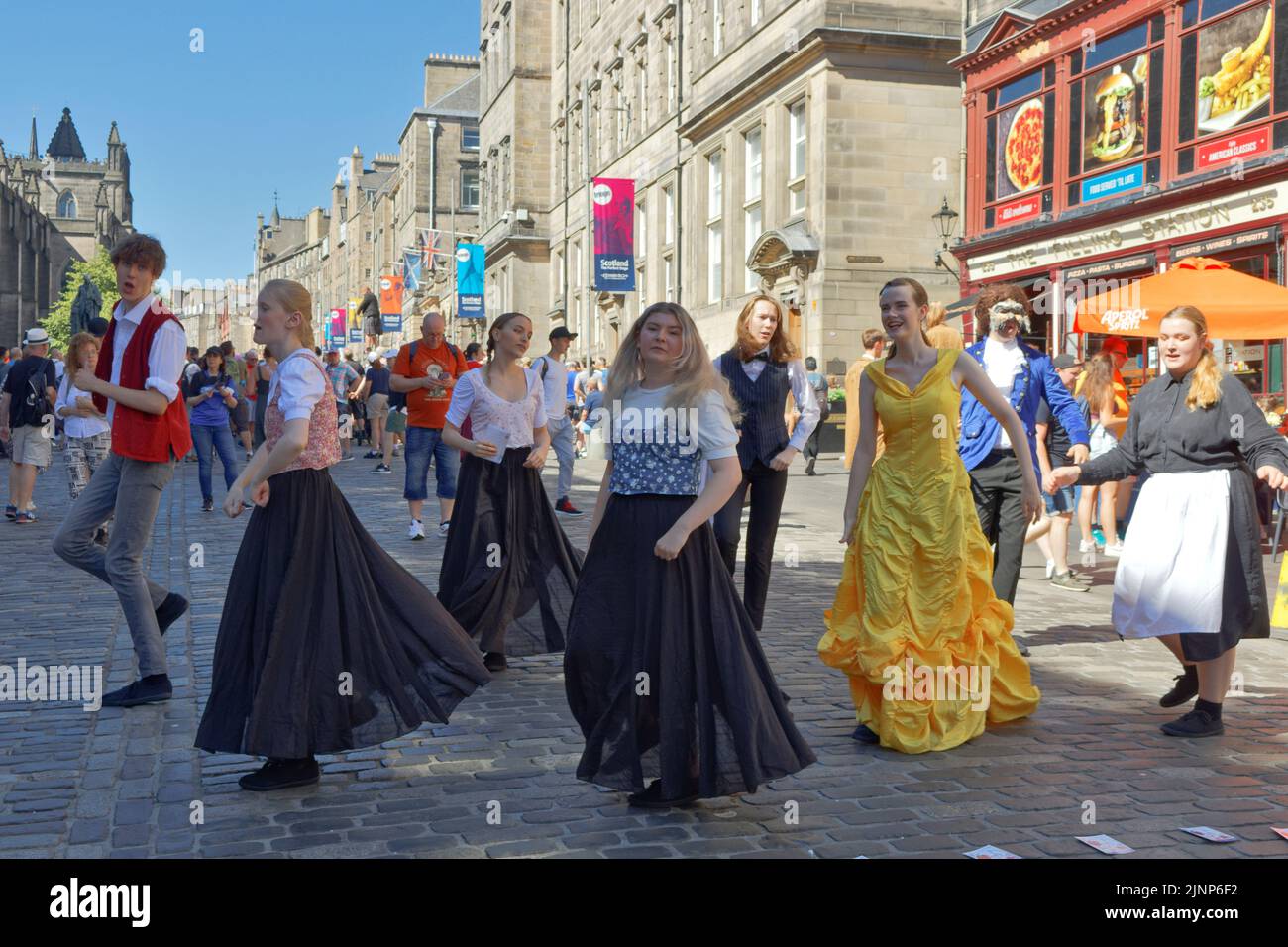 Edimburgo, Scozia, 11 agosto 2022 Festival Fringe Royal Mile il giorno di sole un gruppo di cantanti e ballerini si esibiscono dal gioco Beauty and the Beast Foto Stock