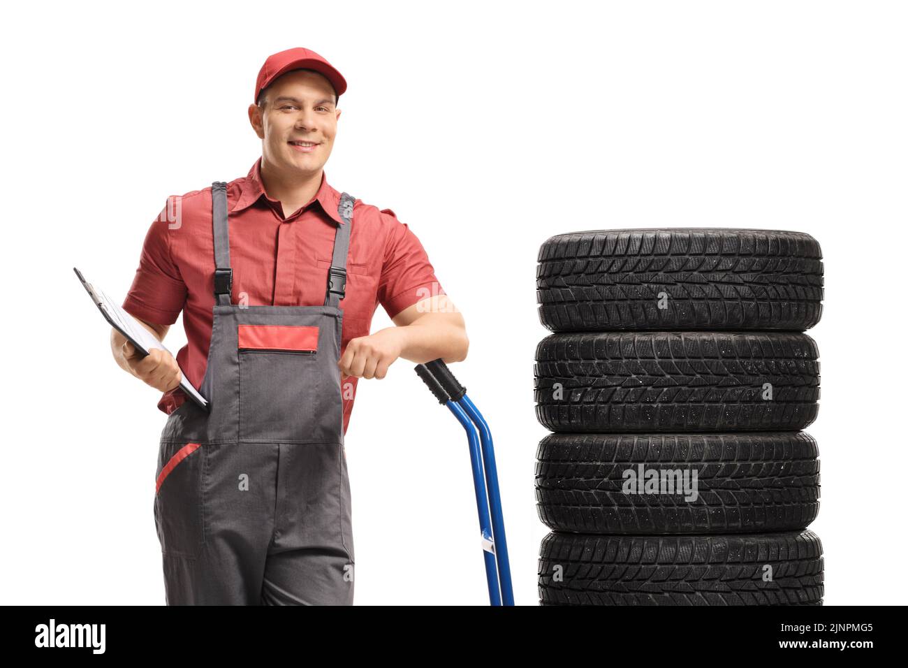 Addetto al magazzino con un portadocumenti appoggiato su un camion manuale con pneumatici del veicolo isolati su sfondo bianco Foto Stock