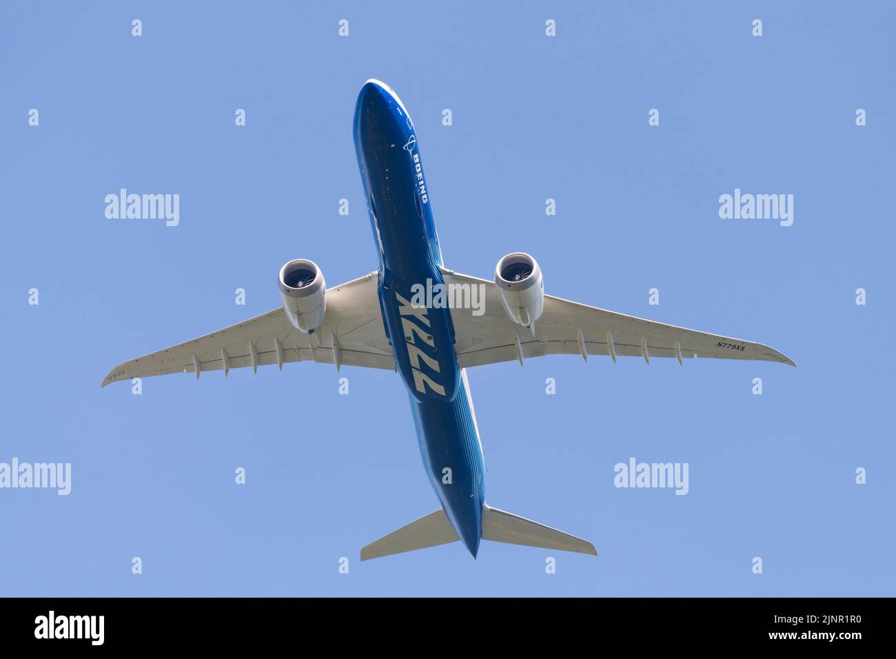 Seattle - 12 agosto 2022; aeromobile Boeing 777X visto dal basso in volo isolato contro il cielo blu chiaro nella livrea della compagnia Foto Stock