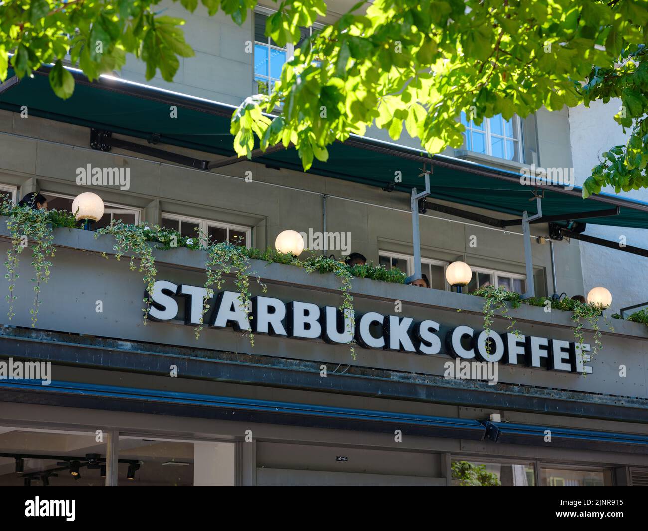 Berna, Svizzera - Luglio 6 2022: Logo Starbucks sulla facciata di un negozio Starbuks. Starbucks è una catena multinazionale americana di caffetterie e di riserve di maestria Foto Stock