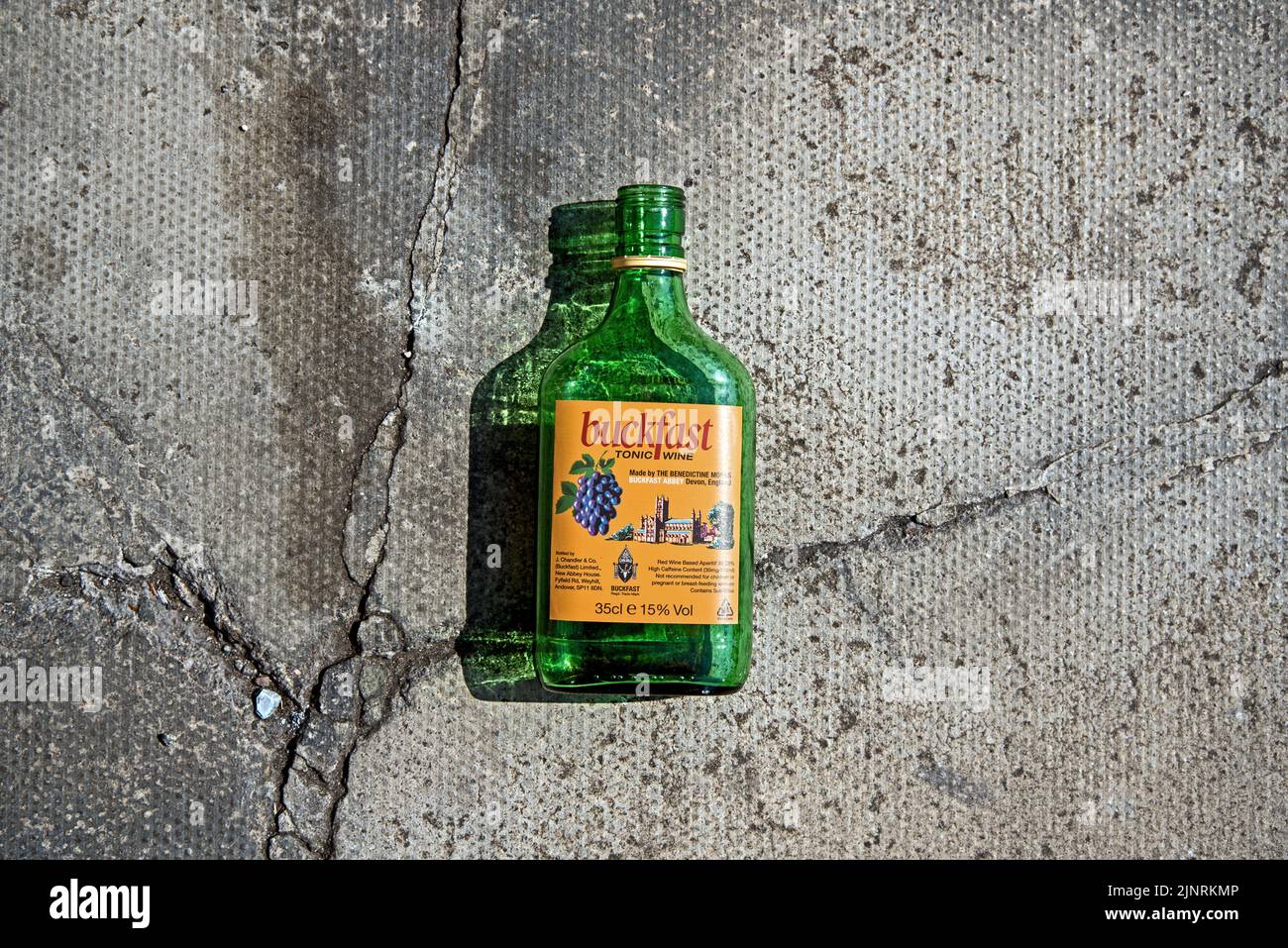 Una bottiglia vuota di Buckfast Tonic Wine, o 'Buckie' come è conosciuto localmente, sul marciapiede di Edimburgo, Scozia, Regno Unito. Foto Stock