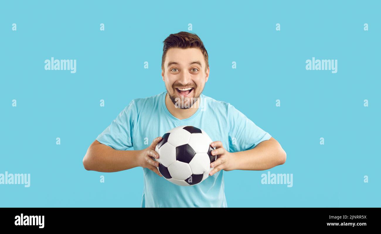 Uomo pieno di gioia con la squadra di calcio di sostegno della sfera Foto Stock