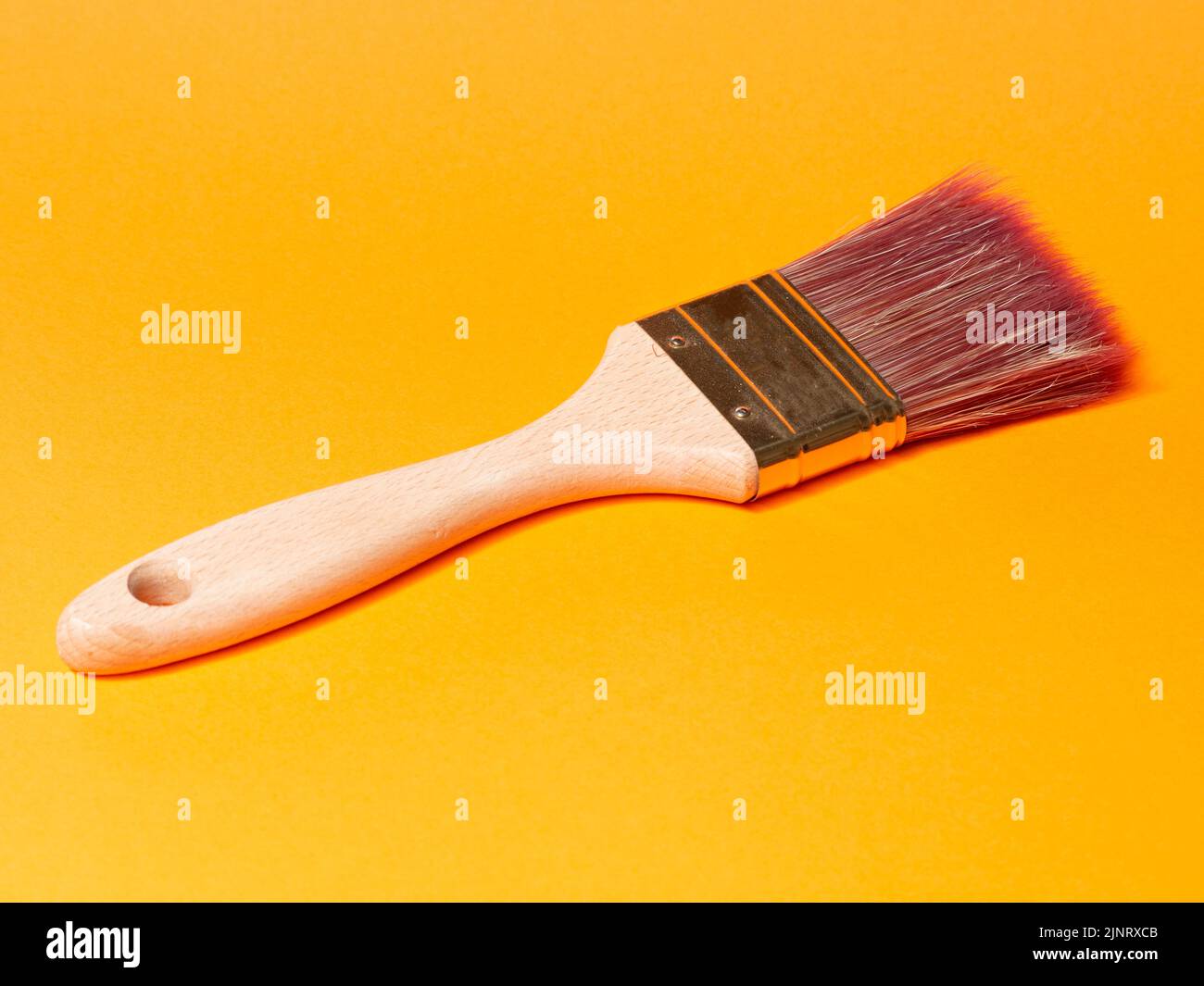 pennello su sfondo arancione. Concetto di riforma Foto Stock