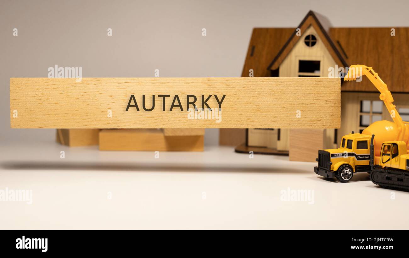 La parola autarky è scritta sulla superficie di legno. Concetto di casa e costruzione in background . Ipoteca ed economia Foto Stock