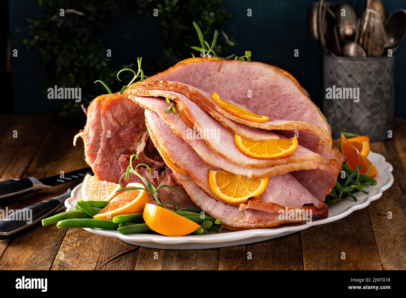 Natale o giorno del Ringraziamento prosciutto a fette con arance ed erbe aromatiche Foto Stock