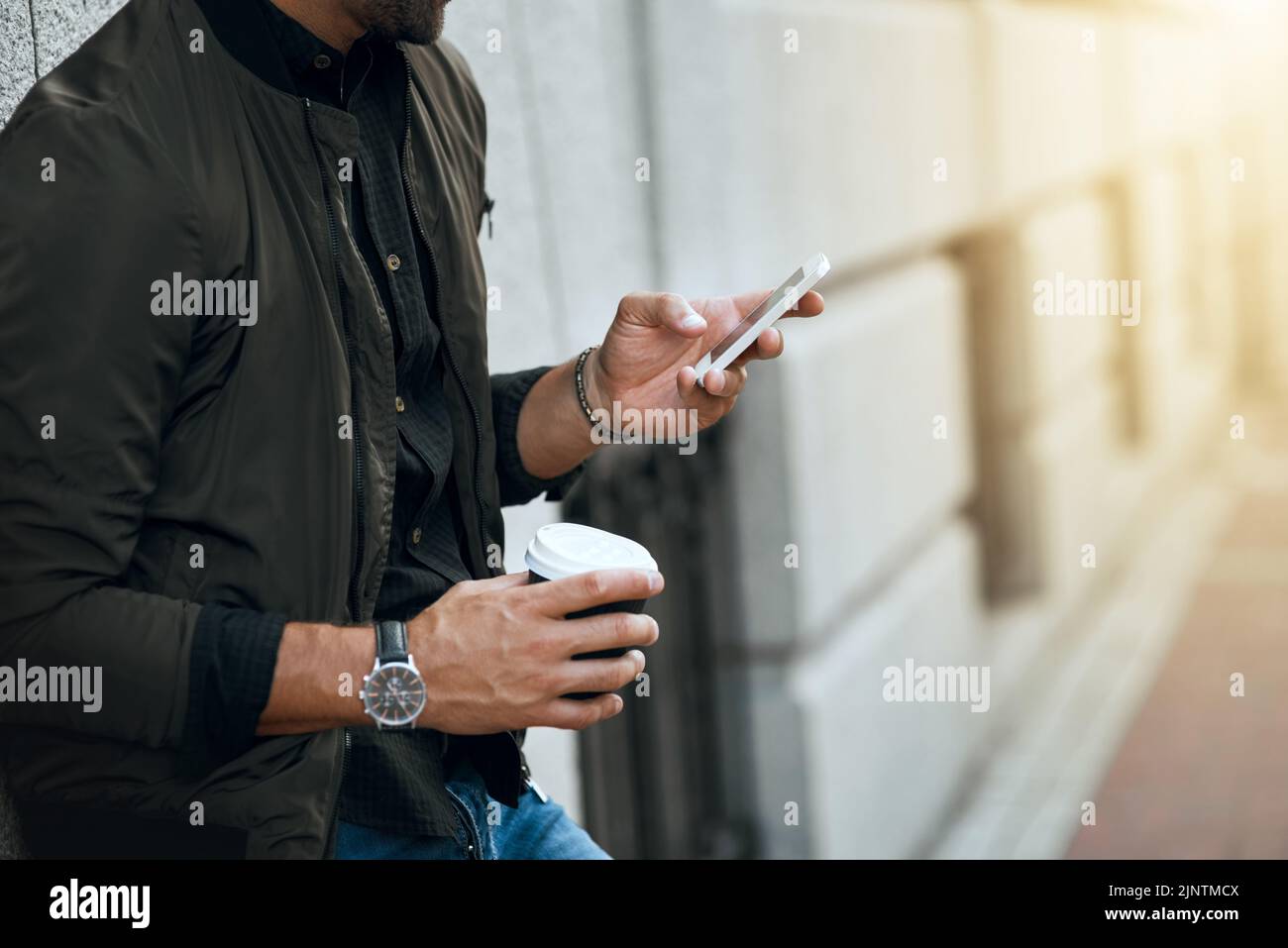 La comunicazione in città. Un uomo irriconoscibile che invia un testo mentre viaggia attraverso la città. Foto Stock