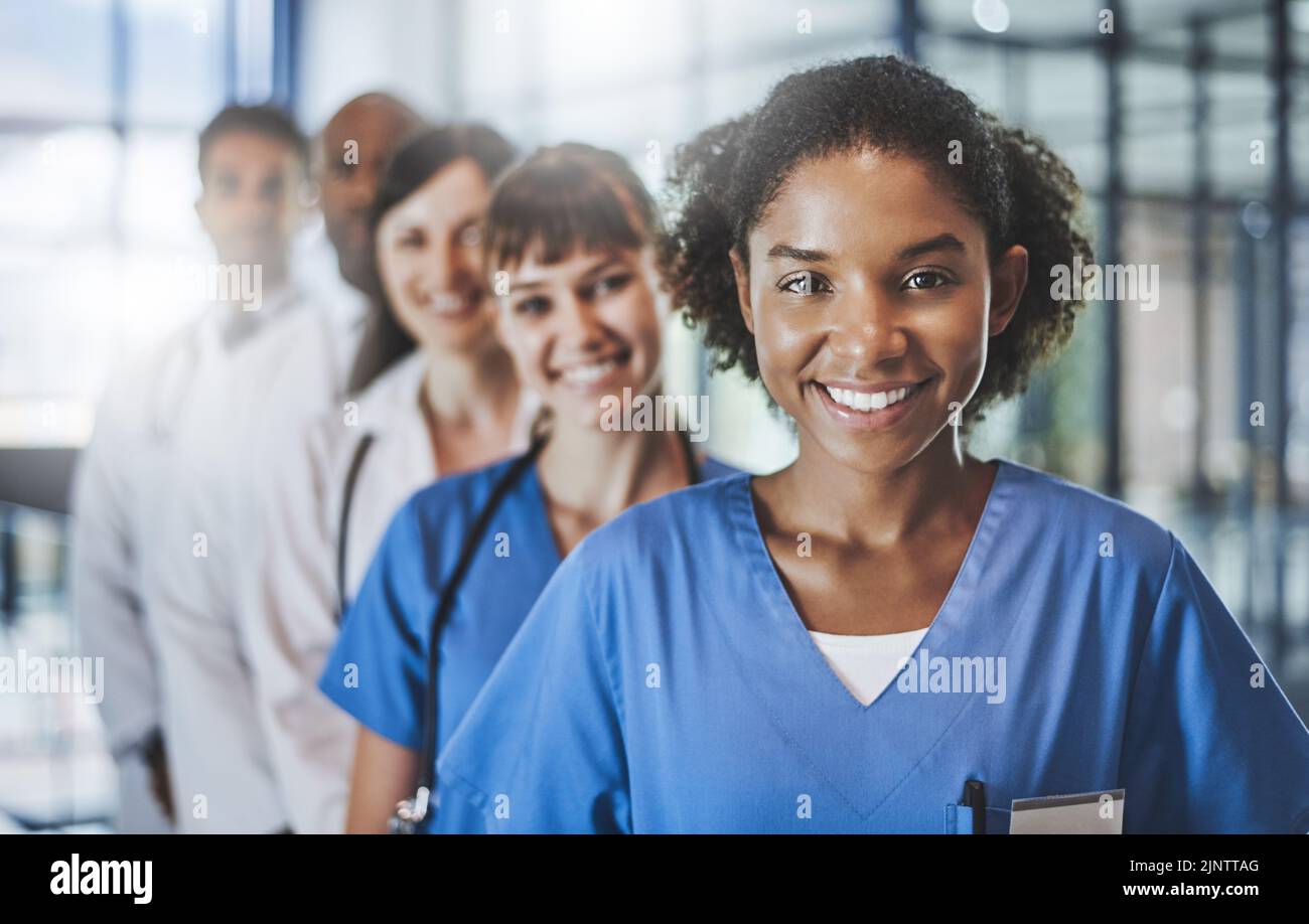 In linea per mantenerli bene. Ritratto di un team di medici diversi in piedi insieme in un ospedale. Foto Stock