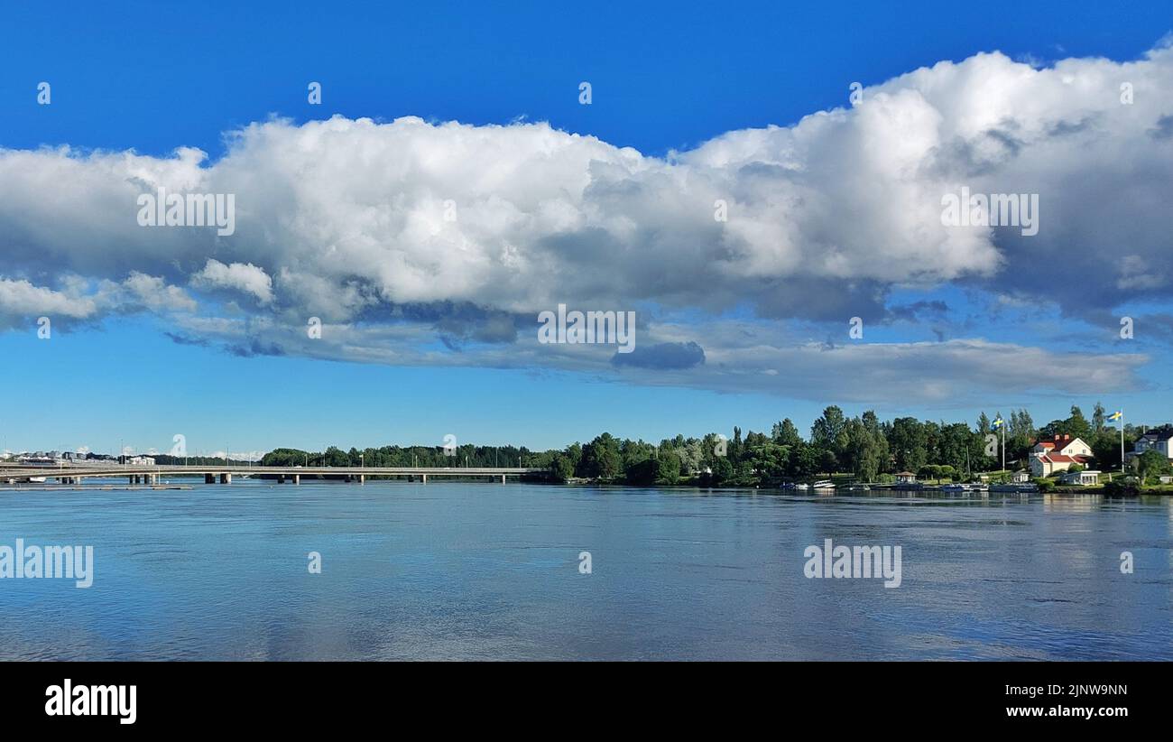 Ponte e nuvole panoramiche sul fiume Ume a Umea, nel nord della Svezia. Foto Stock