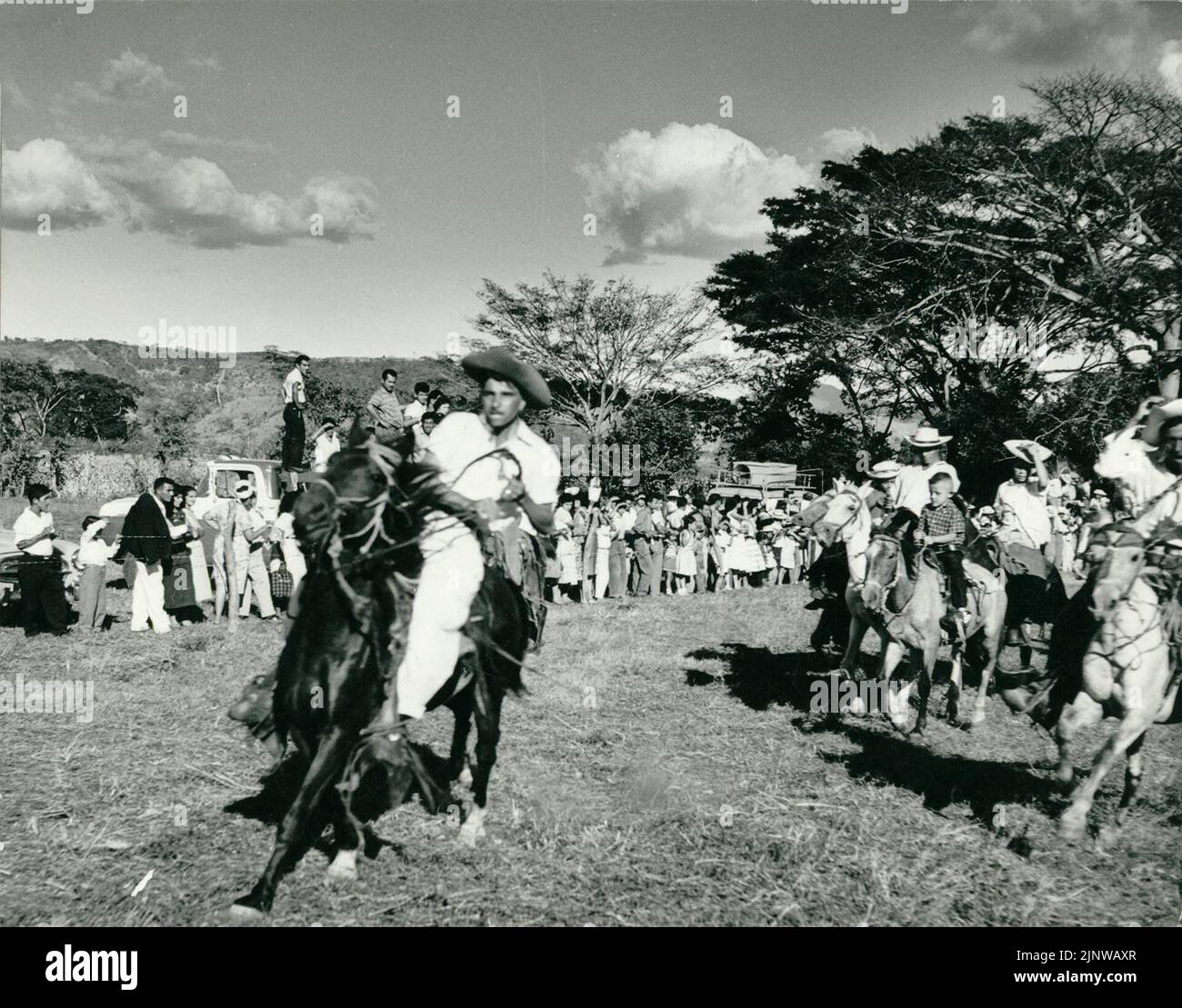 Fotografia in bianco e nero di un uomo che cavalca un cavallo in un rodeo nella campagna di El Salvador, America Centrale Foto Stock