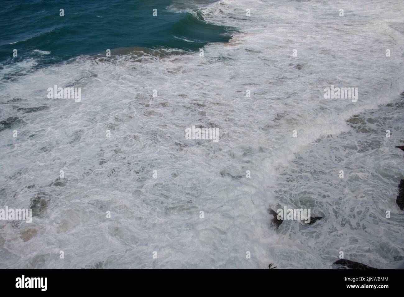 Grandi onde dall'oceano che si schiantano sulla riva e le scogliere Foto Stock