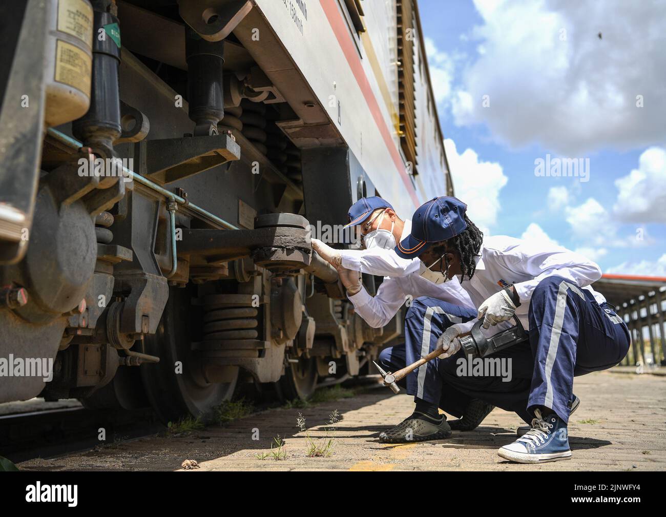 Nairobi, Kenya. 22nd Mar, 2021. L'istruttore cinese Yang Ming (L) e la sua apprendista keniota Concilia ispezionano la locomotiva a Nairobi, Kenya, il 22 marzo 2021. Credit: Li Yan/Xinhua/Alamy Live News Foto Stock