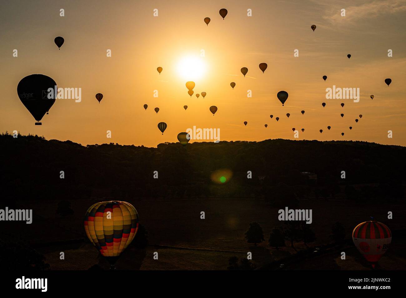 Le mongolfiere volano sopra Bristol e North Somerset alla luce del sole della mattina presto durante l'ascesa di massa della Bristol International Balloon Fiesta 2022. Data immagine: Domenica 14 agosto 2022. Foto Stock