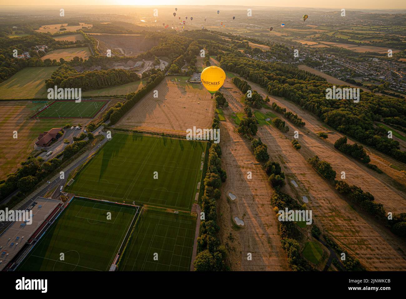 Una mongolfiera vola su un campo da golf dorato e appollaiato la mattina presto, come una siccità è stata dichiarata per parti dell'Inghilterra dopo l'estate più secca per 50 anni. Data immagine: Domenica 14 agosto 2022. Foto Stock