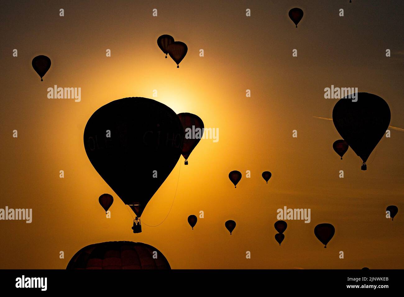 Una mongolfiera passa accanto al sole mentre sorvolano North Somerset alla luce del sole della mattina presto, durante l'ascesa di massa della Bristol International Balloon Fiesta 2022. Data immagine: Domenica 14 agosto 2022. Foto Stock