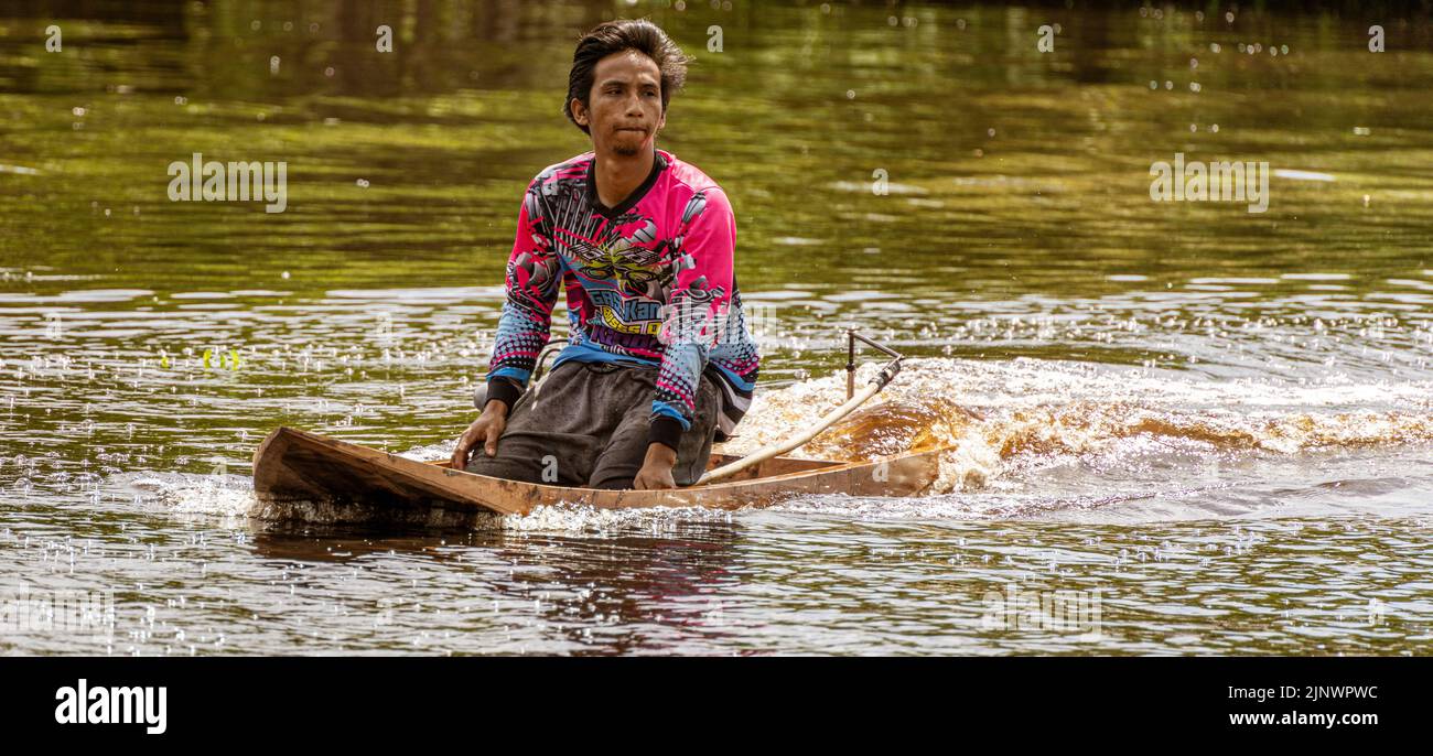 Central Kalamantan, Indonesia, 20 maggio 2022 - uomini nelle loro skimmer barche da corsa che a malapena sgombra l'acqua. Foto Stock