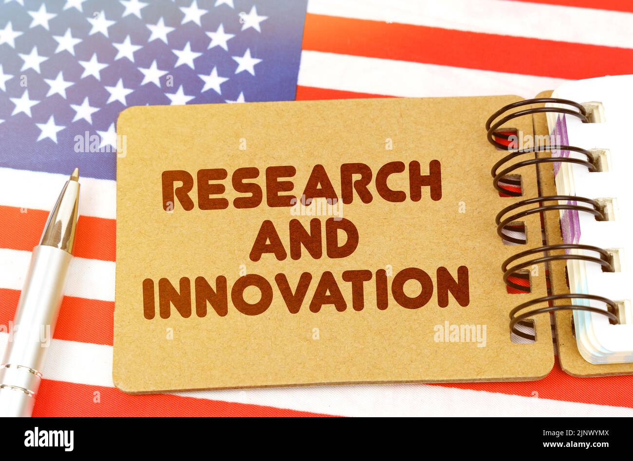 Concetto di economia nazionale. Sulla bandiera degli Stati Uniti si trova un notebook con l'iscrizione - Ricerca e innovazione Foto Stock