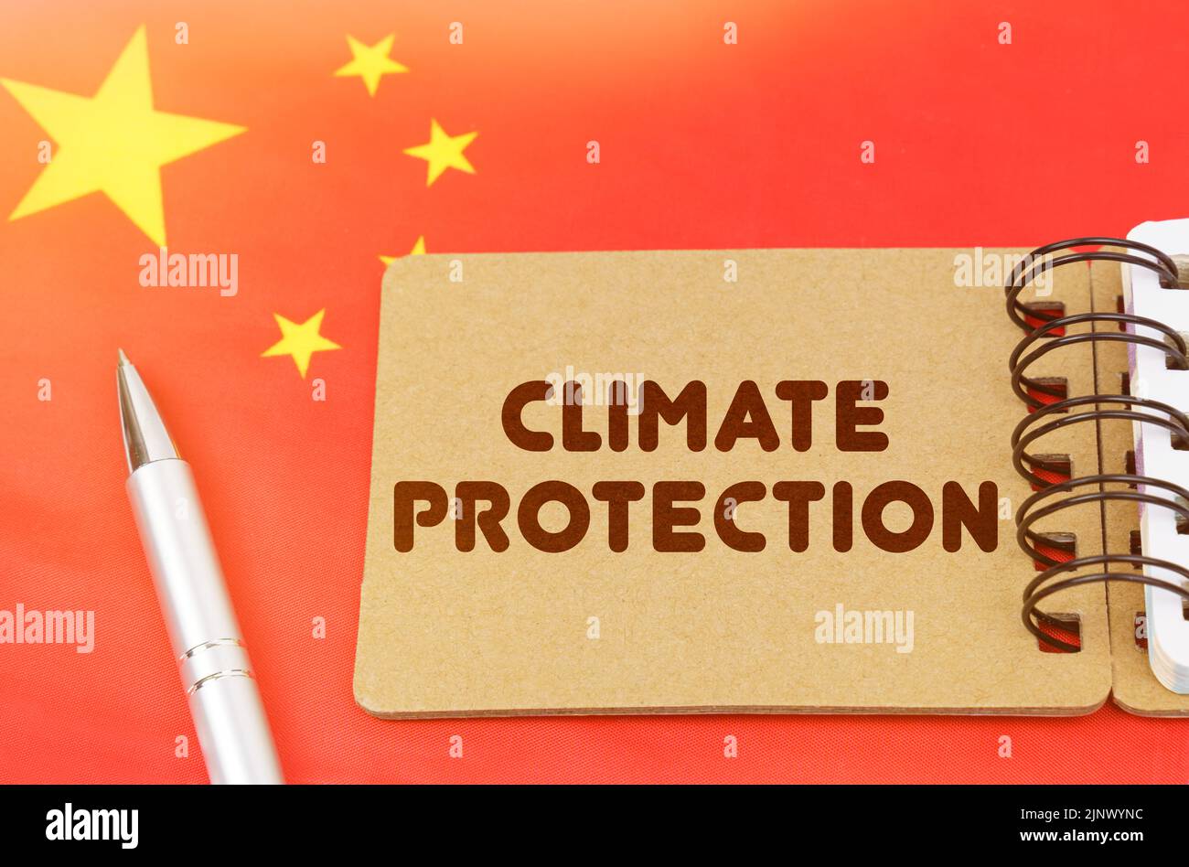 Concetto nazionale di ecologia. Sulla bandiera della Cina si trova un notebook con l'iscrizione - protezione del clima Foto Stock