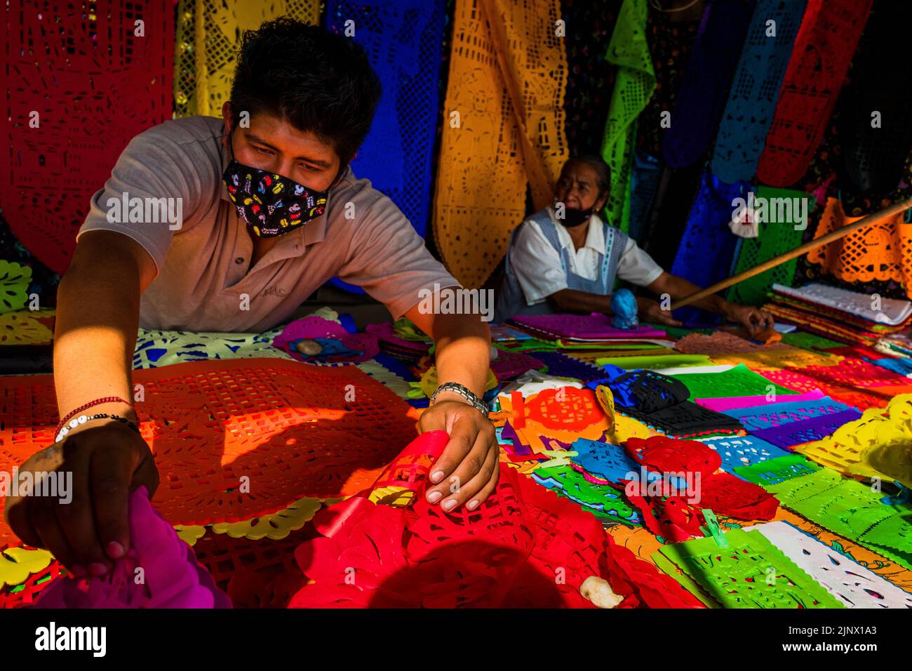 I membri della famiglia indigena messicana vendono bandiere di carta scalpellate per le celebrazioni del giorno dei morti sul mercato di Xochimilco, Messico. Foto Stock