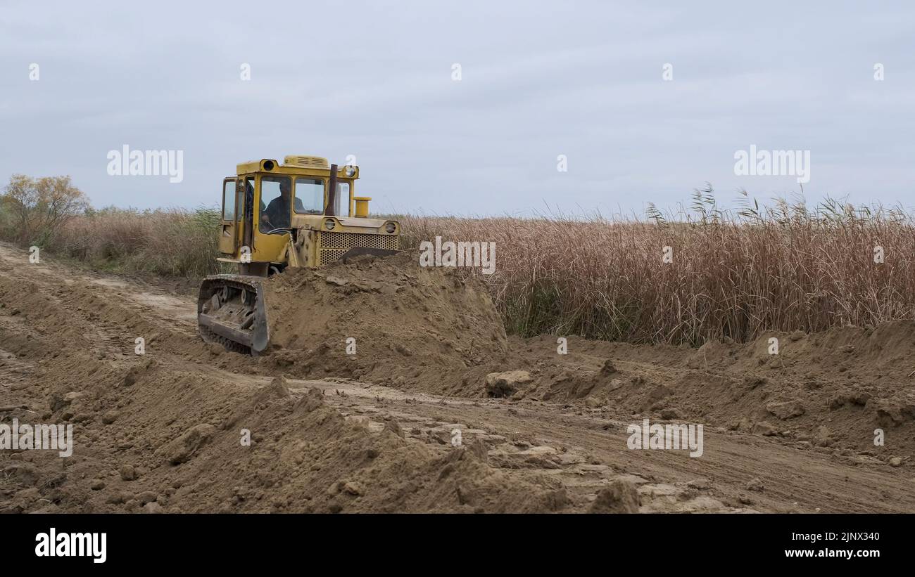 Bull'dozer rimuove la diga nel delta del Danubio. Primo piano Foto Stock