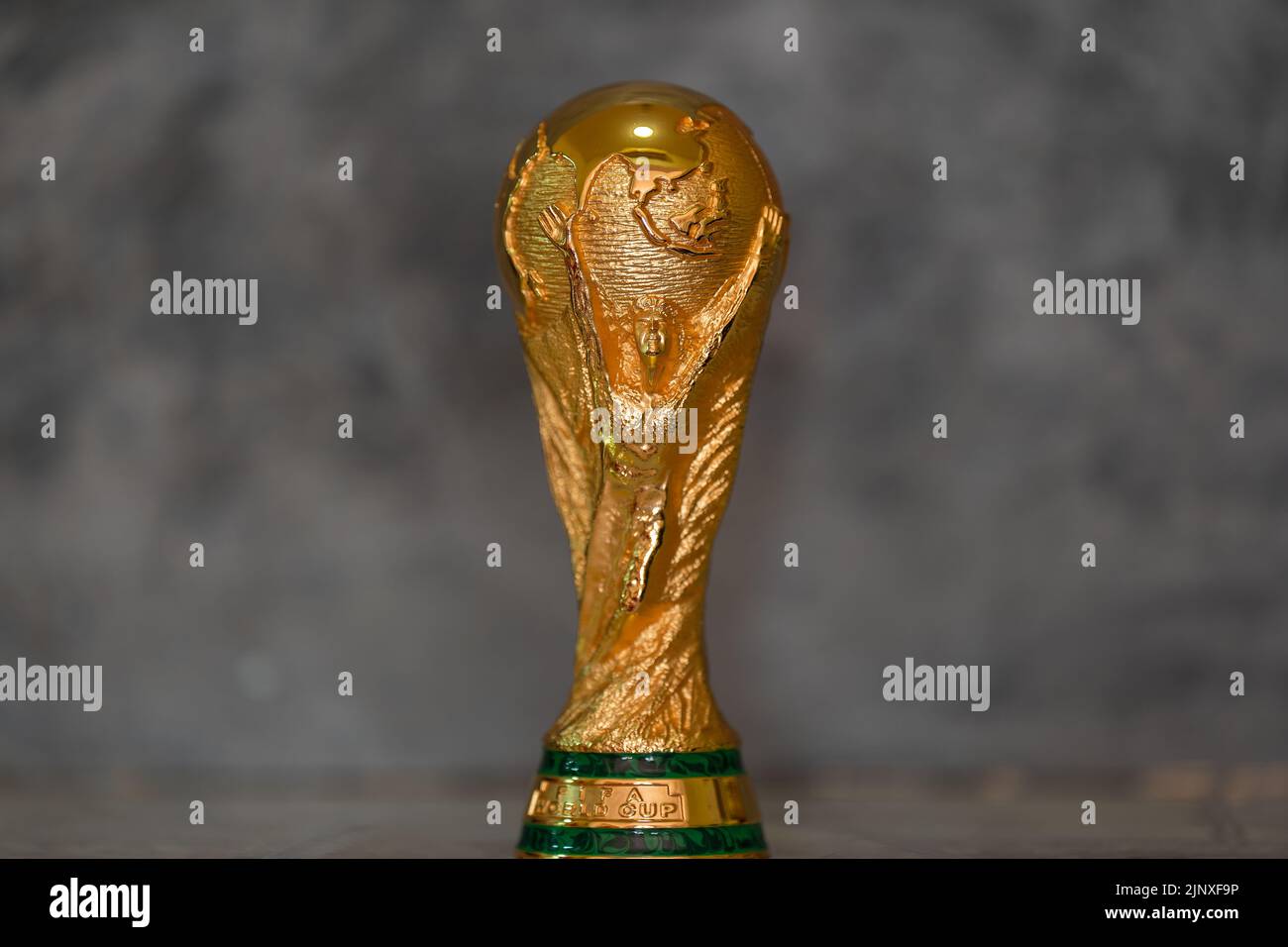 DOHA, QATAR - 14 AGOSTO 2022: Trofeo della Coppa del mondo FIFA su sfondo grigio Foto Stock