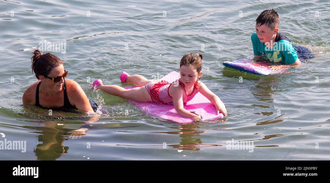 Madre con bambini paddle board in mare in vacanza Foto Stock