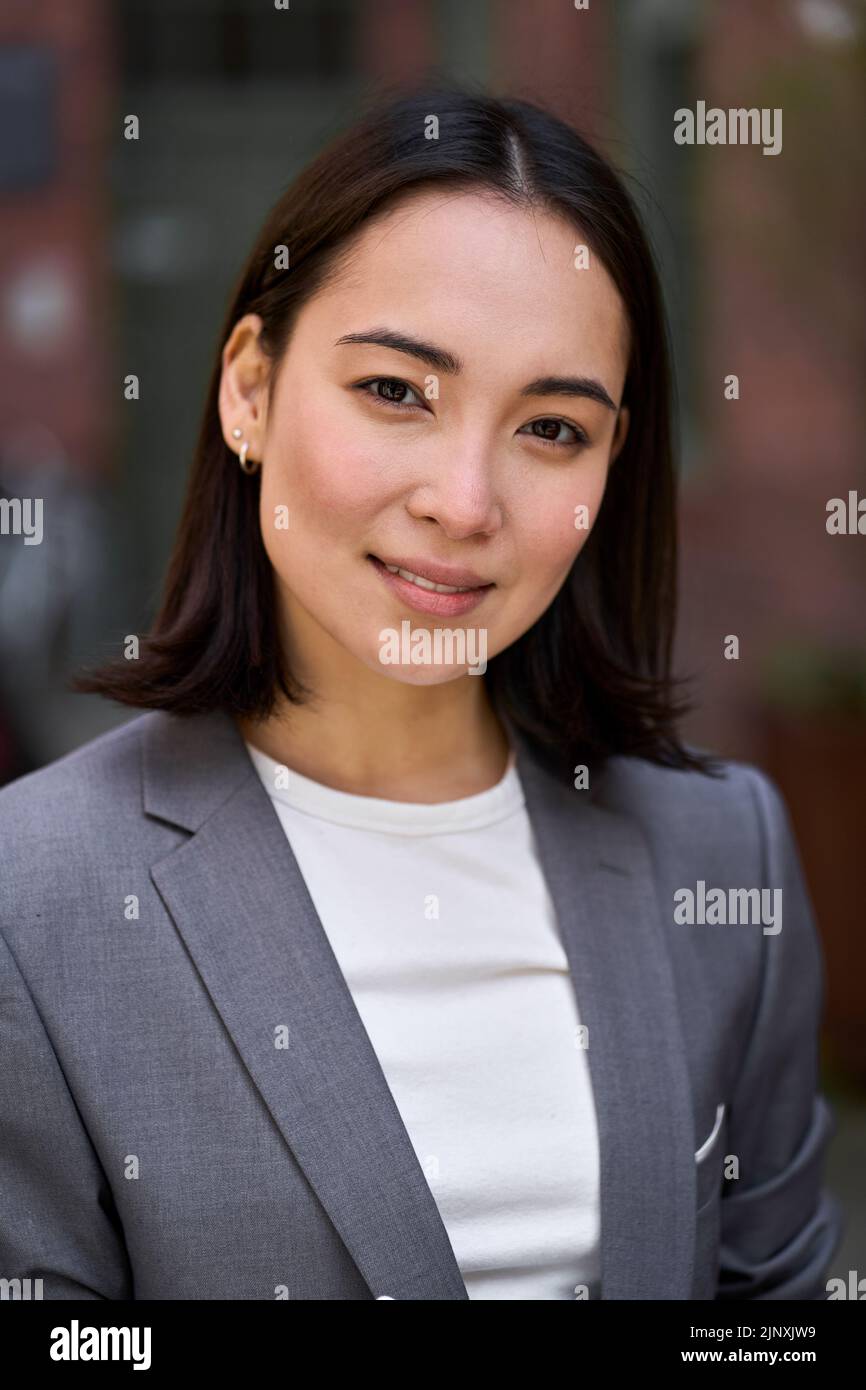 Giovane fiduciosa elegante donna asiatica d'affari, verticale headshot ritratto. Foto Stock