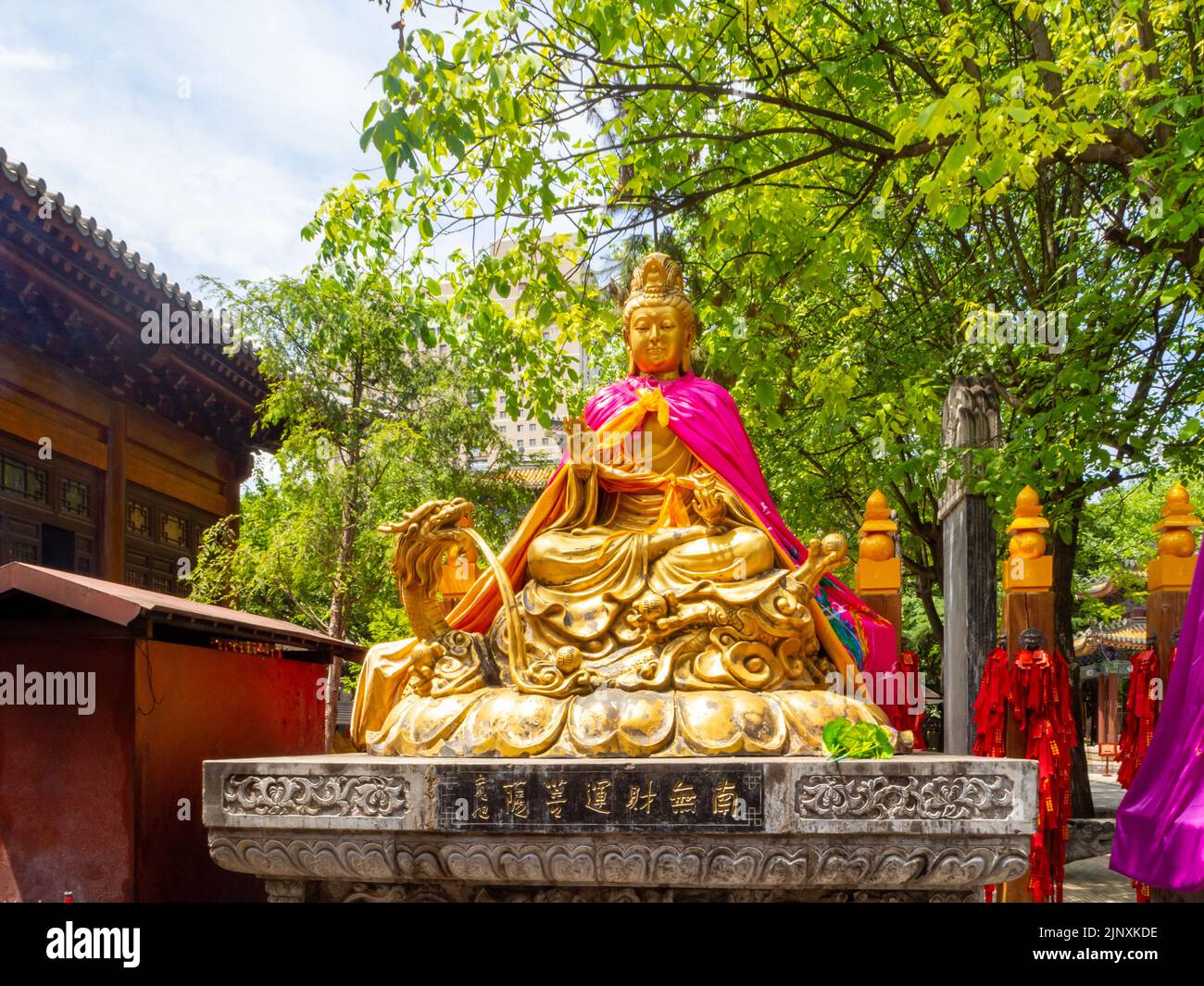 Statua o scultura religiosa cinese dorata in un parco pubblico. Vista frontale del simbolo tradizionale. Foto Stock