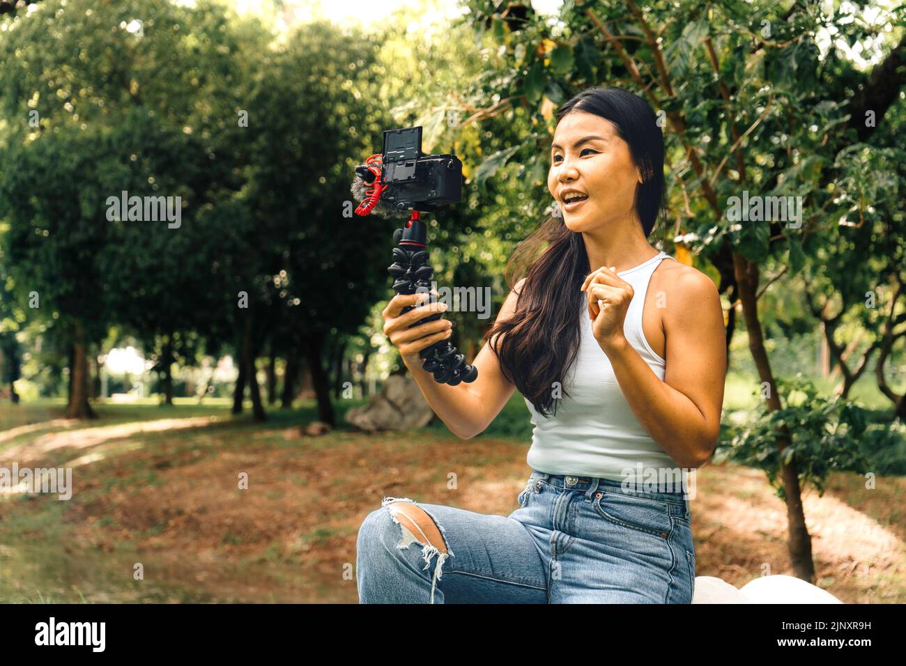 Giovane donna asiatica che registra video con una fotocamera per vlog e social media Foto Stock
