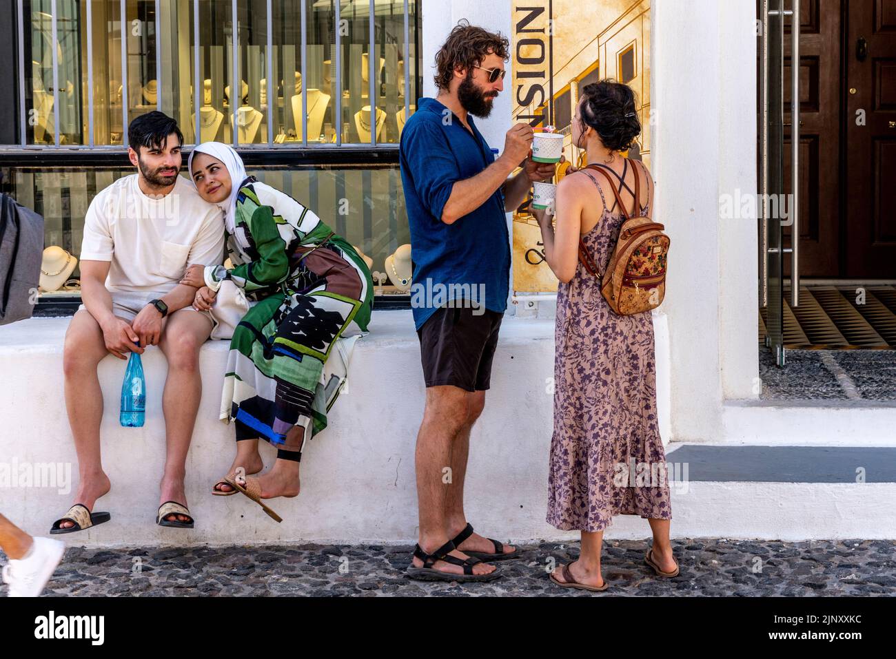 Un gruppo di giovani visitatori nella città di Thira, Santorini, Isole Greche, Grecia. Foto Stock