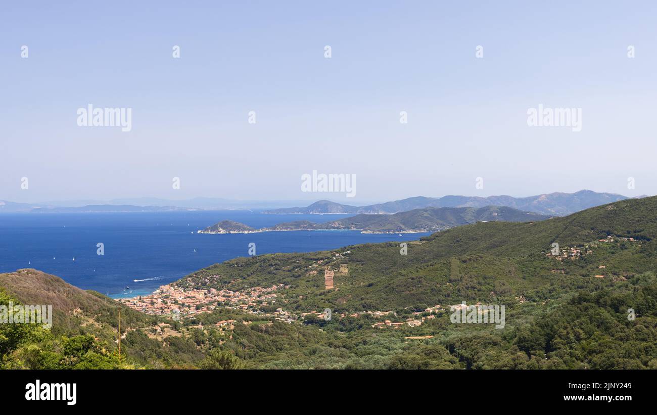 Il paesaggio tipico dell'isola d'Elba è costituito da una serie di montagne basse e densamente boscose, piccoli insediamenti lungo la costa, spiagge sabbiose Foto Stock