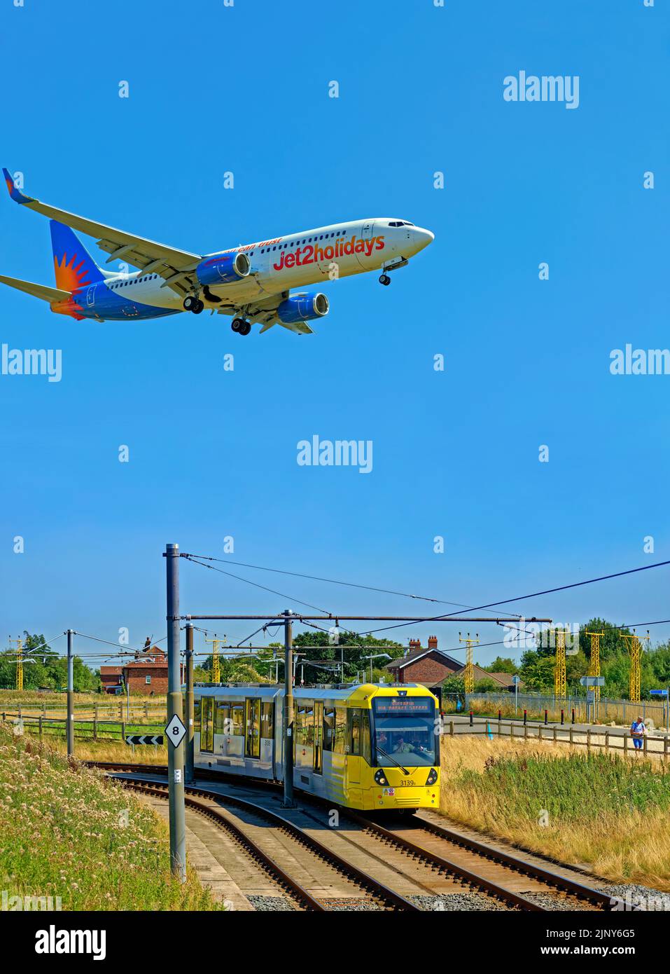 Il tram Manchester Metrolink si avvicina alla stazione dell'aeroporto di Manchester, Manchester, Inghilterra. Foto Stock