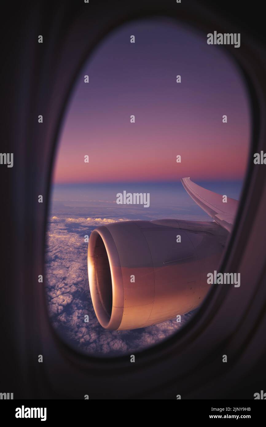 Vista dalla finestra dell'aeroplano durante il volo notturno sopra l'oceano. Focalizzazione selettiva sul motore a reazione. Foto Stock