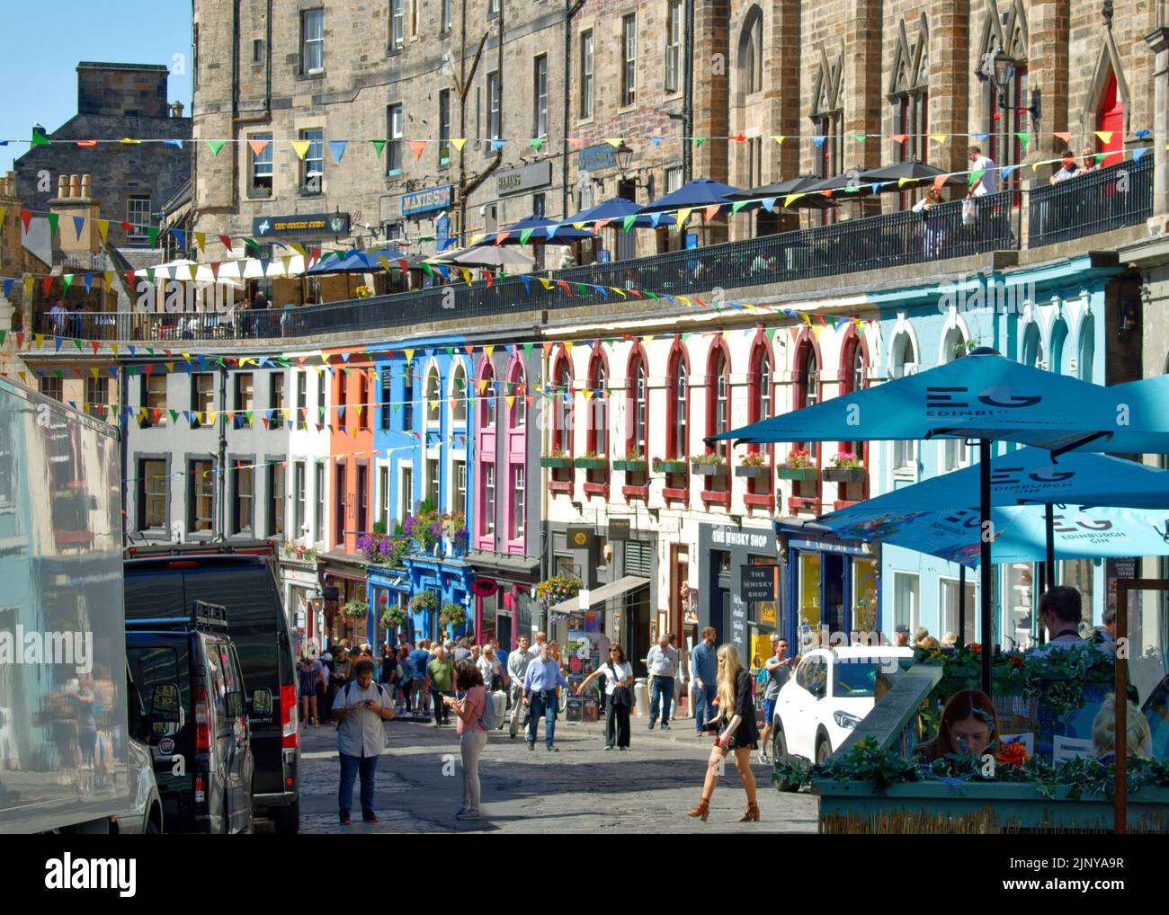 EDIMBURGO CITTÀ SCOZIA I NEGOZI COLORATI FRONTEGGIA UNA VIVACE VICTORIA STREET IN ESTATE Foto Stock