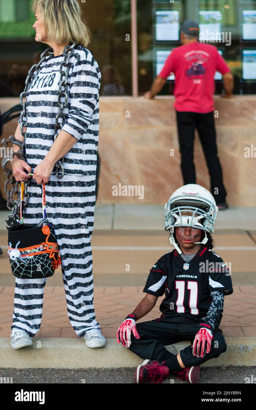 Madre in costume da prigione a righe e figlio in costume da calcio al Fountain Hills Halloween Party in Arizona, USA Foto Stock